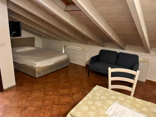 a room with a bed and a couch and a table at La Corte di Vicolo Torre in Uboldo