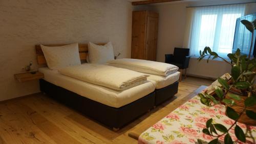 a bedroom with two beds and a plant at Waldrast Bed & Breakfast in Batschuns