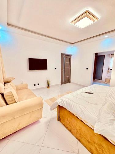 a large bedroom with a bed and a couch at Appart lotus in Cocody
