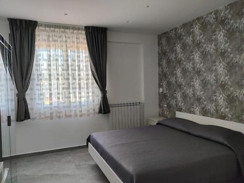a bedroom with a bed and a large window at My Sicily apartments in Taormina