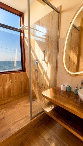 a bathroom with a shower and a sink and a window at Family Surf Chicama in Puerto Chicama