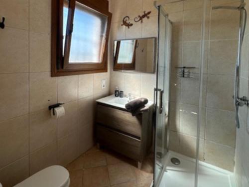a bathroom with a shower and a sink and a toilet at Vila Girasoles in Cálig