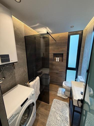 a bathroom with a washing machine and a toilet at Villas Çeremi in Maskollatë