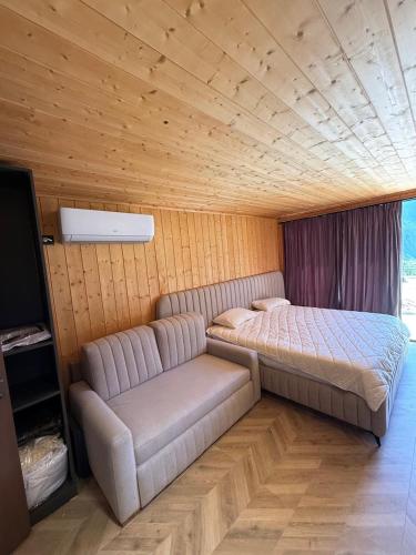 a bedroom with a bed and a couch in it at Villas Çeremi in Maskollatë