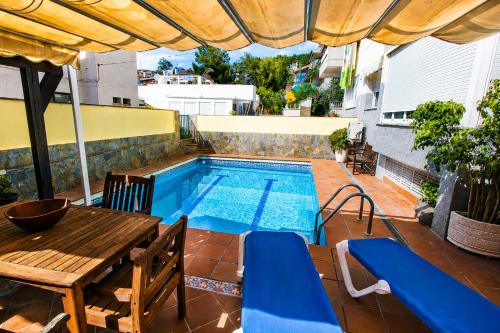 a patio with a table and a swimming pool at Buda Villa Planetcostadorada in Salou