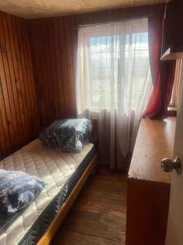 a bedroom with two beds and a window at Alojamiento Halcones in Concepción