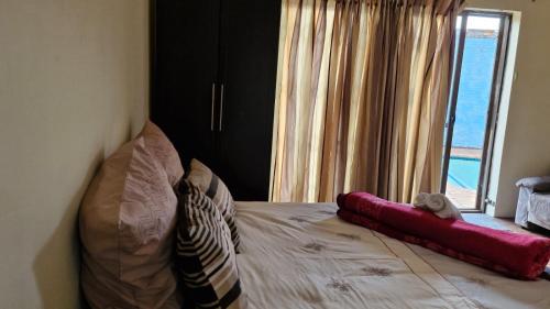a bedroom with a bed with a large window at Self Contained Batchelor pad in Germiston