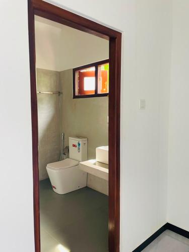 a bathroom with a toilet and a sink and a mirror at Villa Serandiva in Galle