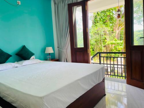 a bedroom with a large bed and a balcony at Villa Serandiva in Galle