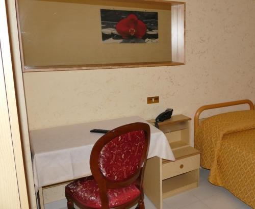 a room with a desk and a chair and a bed at Hotel L'Ulivo in Mirabella Eclano