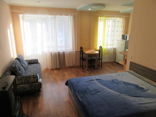 ペルミにあるApartments on Krasnovaのベッド、ソファ、テーブルが備わる客室です。