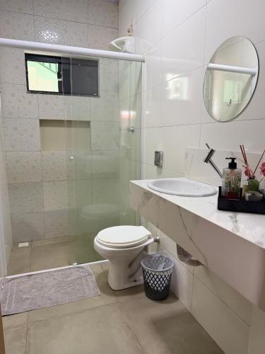 a white bathroom with a toilet and a sink at Apartamento minutos do centro in Sinop