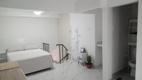 a white bedroom with a bed and a toilet at SandritaHouse in Tuluá