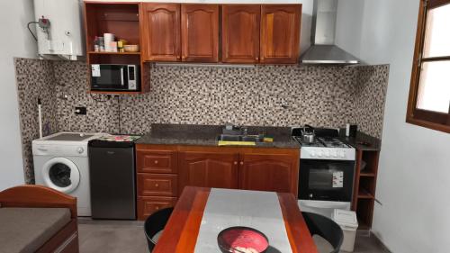 a kitchen with wooden cabinets and a table in it at Renzo in Deán Funes