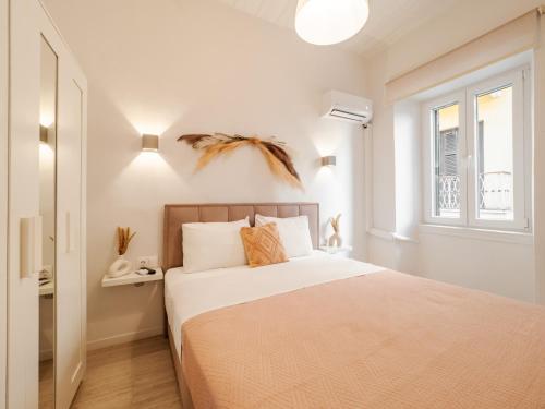 a white bedroom with a bed and a window at Nena's Volto, Campiello living in Corfu