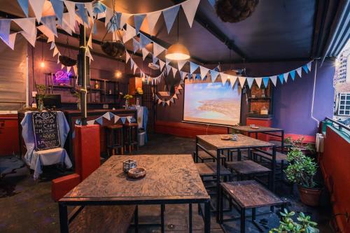 a restaurant with tables and chairs in a room with flags at Hostel & Spa Mediterránea in Córdoba
