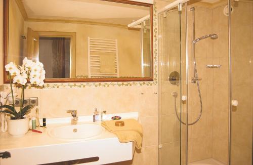 a bathroom with a sink and a shower at Schwarzwaldhotel Klumpp in Baiersbronn