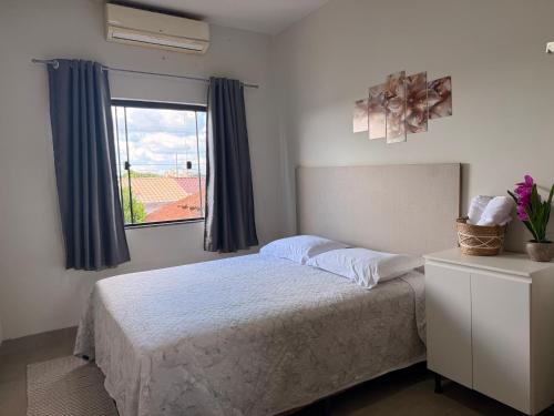 a bedroom with a bed and a window at Apartamento com 2 quartos próximo do centro in Sinop