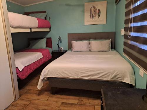 two beds in a room with two bunk beds at HOSTAL EL ARoMO CHILLÁN in Chillán