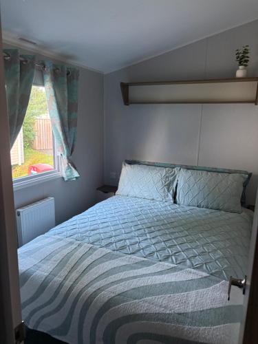 a bedroom with a bed and a window at Sea Breeze Lodge in Longniddry