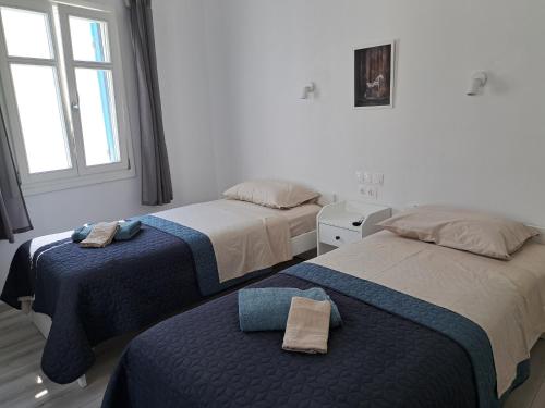 two beds in a white room with a window at ALSIDE Apartment in Aegiali
