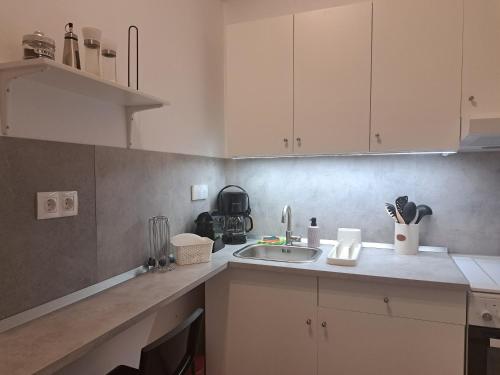 a kitchen with white cabinets and a sink at ALSIDE Apartment in Aegiali