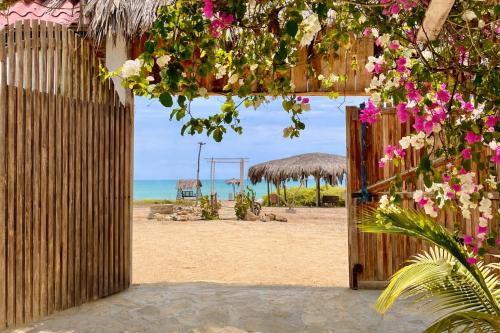 an open door to a beach with flowers on it at Nativo Lodge in Playas