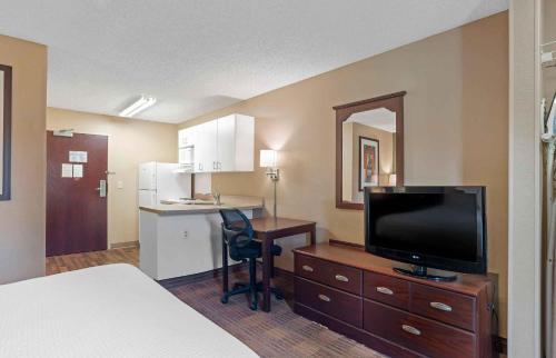 a hotel room with a bed and a desk with a television at Extended Stay America Suites - San Diego - Oceanside in Oceanside