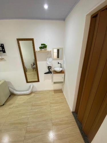 a hallway with a mirror and a sink in a room at kitnet Residencial Ozzy com Garagem Coberta em Betim in Betim