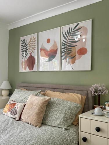 a bedroom with four pictures hanging above a bed at King room with garden access in Raynes Park