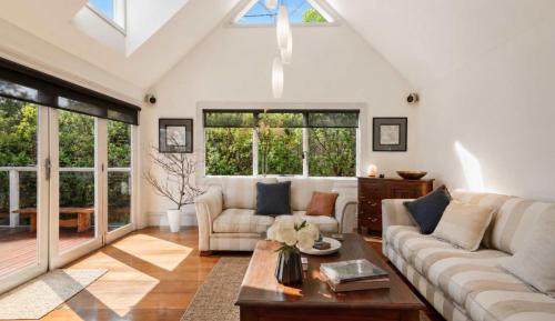 a living room with a couch and a table at Casa Con Vista Luxury Waterfront Home, Sleeps 10 in Hobart