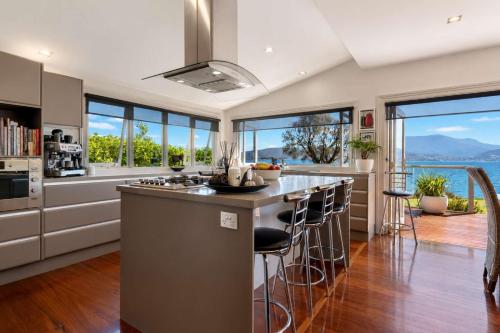 a kitchen with a large island with bar stools at Casa Con Vista Luxury Waterfront Home, Sleeps 10 in Hobart