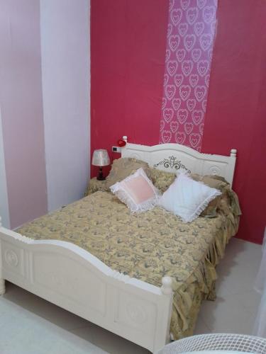 a bedroom with a white bed with pink and purple walls at إقامة تسنيم in Selouane