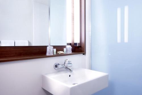 a bathroom with a white sink and a mirror at Campanile Chartres in Chartres