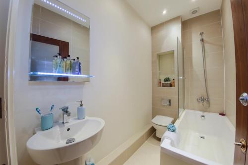 y baño con lavabo, aseo y ducha. en Finchley Central Spacious 3 bed triplex loft style apartment en Hendon