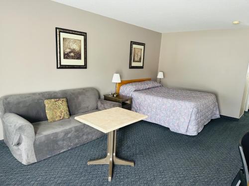 ein Hotelzimmer mit Sofa und Bett in der Unterkunft Heritage Inn in Hope