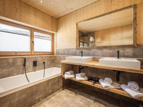 a bathroom with two sinks and a tub and a bath tubermott at Chalet with mountain views, Dein Bichlbach in Bichlbach