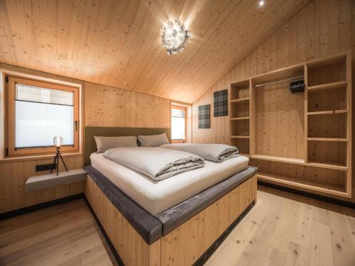 a bedroom with a large bed in a wooden room at Bichlbach Chalet with sauna in Bichlbach