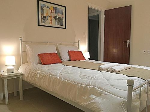 a bedroom with a large bed with two red pillows at Demeliza Apartments in Plaka
