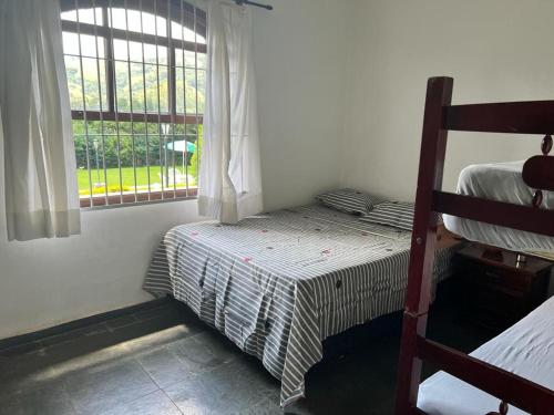a bedroom with a bunk bed and a window at Recanto Rosa Maria in Monte Sião