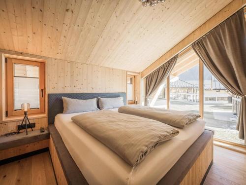 a bedroom with a large bed and a large window at Your bright chalet with sauna in Bichlbach in Bichlbach