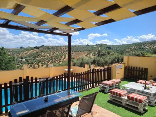 a patio with a table and chairs and a fence at Villa in Andalusia with Private Pool in Fuentes de Cesna