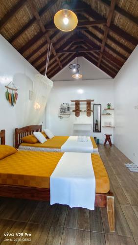 two beds in a room with wooden floors at Puriran's Hometel in Basco