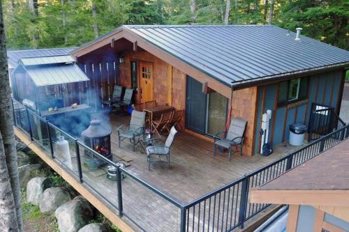a cabin with a grill on a deck at The Great Escape - Port Renfrew in Port Renfrew