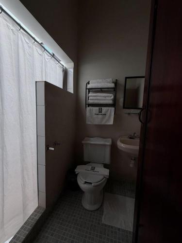 a bathroom with a toilet and a sink at Hotel Puerta de Jade in Ciudad Valles