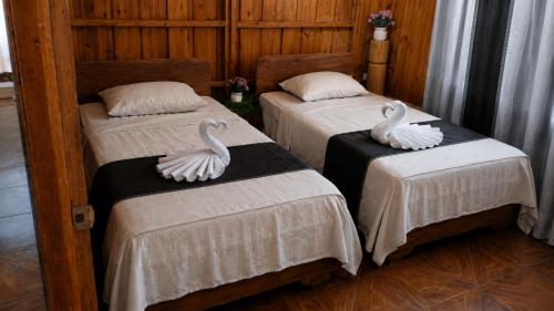 two swans sitting on two beds in a room at Maye WOOD APT in Uvita