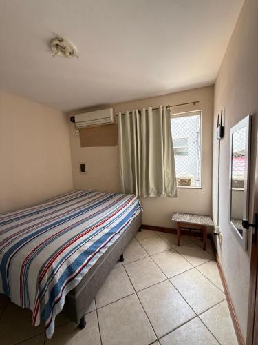 a small bedroom with a bed and a window at Temporada Ilhéus Centro in Ilhéus
