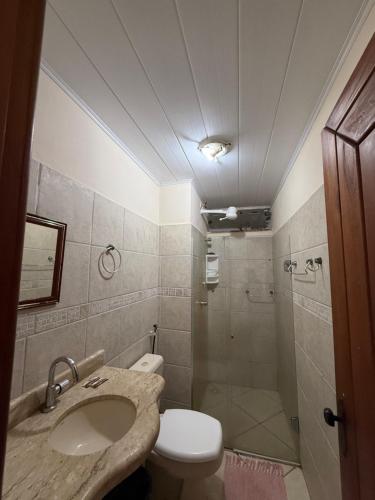 a bathroom with a sink and a toilet and a shower at Temporada Ilhéus Centro in Ilhéus