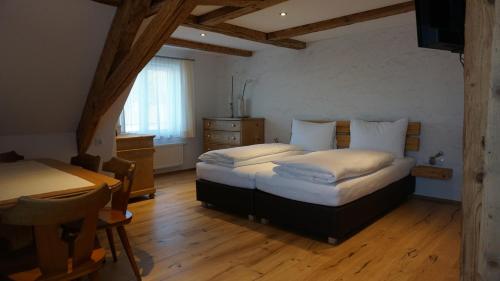 a bedroom with two beds and a table in it at Waldrast Bed & Breakfast in Batschuns