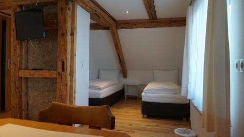a room with two beds and a table and a tv at Waldrast Bed & Breakfast in Batschuns